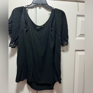 Cold shoulder blouse with crocheted sleeve trim.